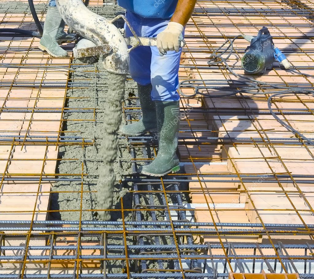 Workers pouring concrete on big floor construction