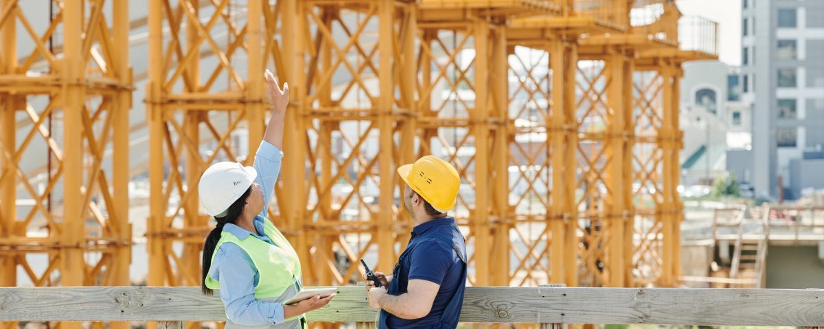 a man and a woman with ppe s talking at a construction site