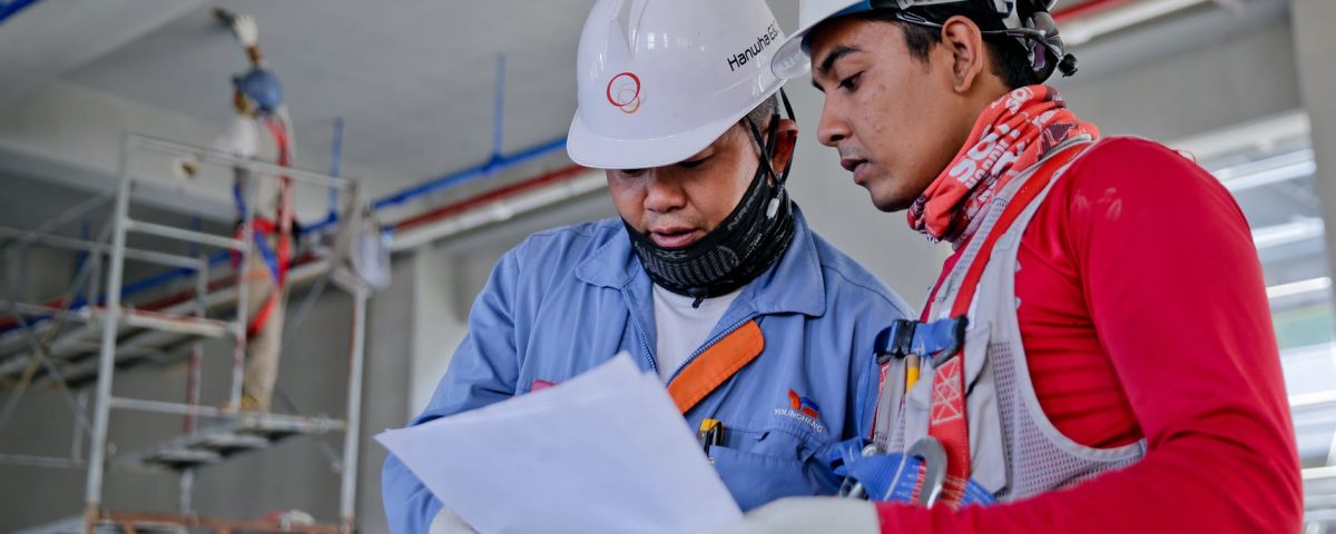two man holding white paper