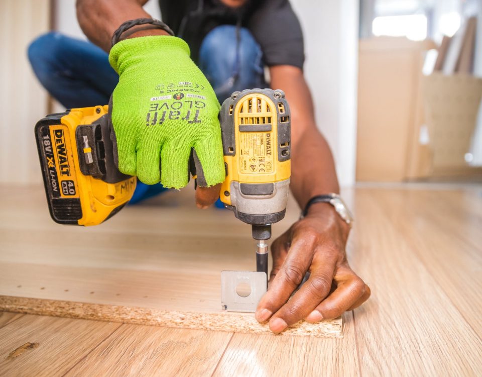 person using dewalt cordless impact driver on brown board